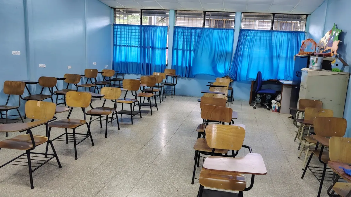 Bilik darjah kosong dengan kerusi kayu dan langsir biru