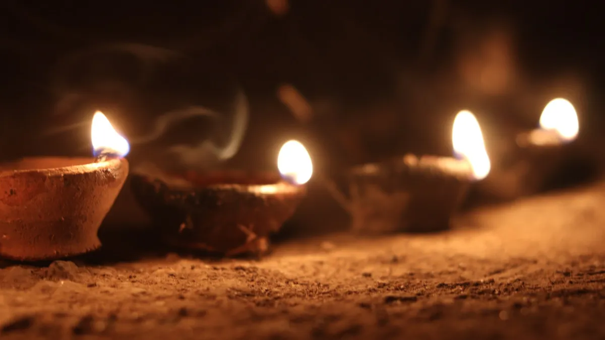 A row of lit clay oil lamps