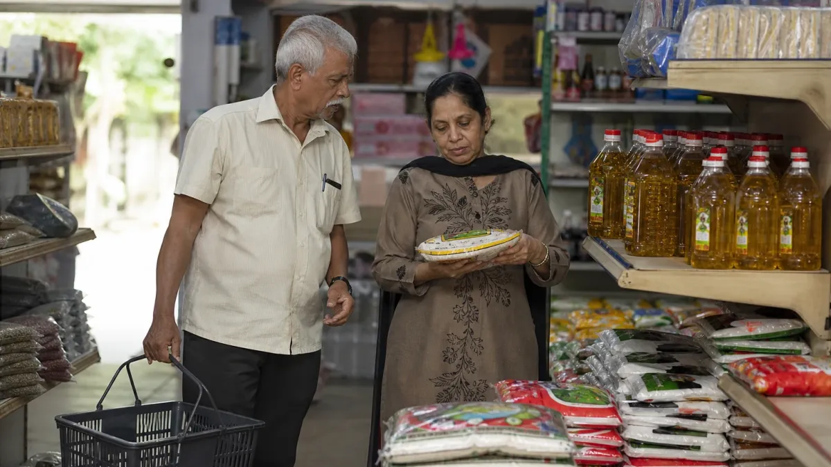 An elderly couple buy rice and cooking oil at a grocery shop